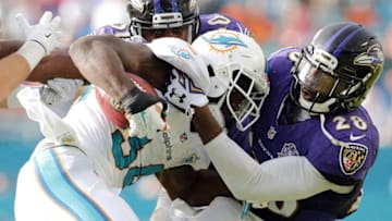 Dec 6, 2015; Miami Gardens, FL, USA; Miami Dolphins running back Damien Williams (34) is tackled by Baltimore Ravens free safety Brynden Trawick (28) during the second half at Sun Life Stadium. The Dolphins won 15-13. Mandatory Credit: Steve Mitchell-USA TODAY Sports