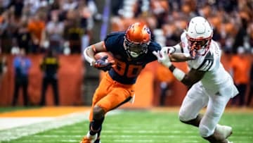 SYRACUSE, NY - NOVEMBER 09: Taj Harris #80 of the Syracuse Orange delivers a stiff arm to Cornelius Sturghill #3 of the Louisville Cardinals during the second quarter at the Carrier Dome on November 9, 2018 in Syracuse, New York. (Photo by Brett Carlsen/Getty Images)