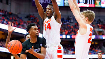 SYRACUSE, NY - DECEMBER 18: Montell McRae #1 of the Buffalo Bulls passes the ball around defenders Bourama Sidibe #34 and Marek Dolezaj #21 of the Syracuse Orange during the first half at the Carrier Dome on December 18, 2018 in Syracuse, New York. (Photo by Brett Carlsen/Getty Images)