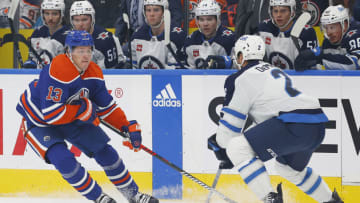 Sep 24, 2023; Edmonton, Alberta, CAN; Edmonton Oilers forward Mattias Janmark (13) chips the puck past Winnipeg Jets defensemen Dylan DeMelo (2) during the first period at Rogers Place. Mandatory Credit: Perry Nelson-USA TODAY Sports