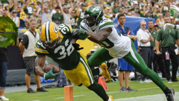 GREEN BAY, WISCONSIN - AUGUST 21: Kylin Hill #32 of the Green Bay Packers scores a touchdown against Marcus Maye #20 of the New York Jets in the first half during a preseason game at Lambeau Field on August 21, 2021 in Green Bay, Wisconsin. (Photo by Quinn Harris/Getty Images)