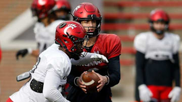Cincinnati Bearcats quarterback Evan Prater hands off during a spring practice at Nippert Stadium. The Enquirer.