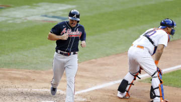 NEW YORK, NEW YORK - JULY 25: Adam Duvall #23 of the Atlanta Braves scores a run in the tenth inning past Wilson Ramos #40 of the New York Mets after starting the inning on second base at Citi Field on July 25, 2020 in New York City. The 2020 season had been postponed since March due to the COVID-19 pandemic. The Braves defeated the Mets 5-3 in ten innings. (Photo by Jim McIsaac/Getty Images)