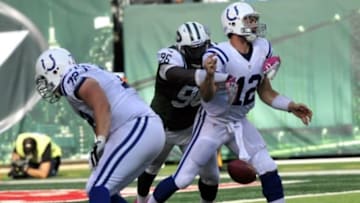 Oct 14, 2012; East Rutherford, NJ, USA; Indianapolis Colts quarterback Andrew Luck (12) fumbles after being hit by New York Jets defensive lineman Muhammad Wilkerson (96) during the second half at Metlife Stadium. The Jets won the game 35-9. Mandatory Credit: Joe Camporeale-USA TODAY Sports