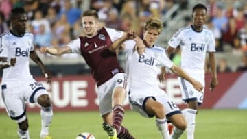 Jul 4, 2015; Commerce City, CO, USA; Whitecaps FC defender Diego Rodriguez (18) and Colorado Rapids forward Kevin Doyle (9) battle for control of the ball during the second half at Dick's Sporting Goods Park. The Rapids won 2-1. Mandatory Credit: Chris Humphreys-USA TODAY Sports