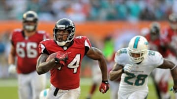 Sep 22, 2013; Miami Gardens, FL, USA; Atlanta Falcons fullback Jason Snelling (44) runs past Miami Dolphins cornerback Nolan Carroll (28) during the second half at Sun Life Stadium. Mandatory Credit: Steve Mitchell-USA TODAY Sports