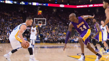 January 14, 2016; Oakland, CA, USA; Golden State Warriors guard Stephen Curry (30, left) dribbles the basketball against Los Angeles Lakers forward Kobe Bryant (24) during the first quarter at Oracle Arena. The Warriors defeated the Lakers 116-98. Mandatory Credit: Kyle Terada-USA TODAY Sports