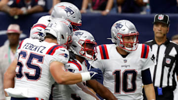 HOUSTON, TEXAS - OCTOBER 10: Mac Jones #10 of the New England Patriots and Josh Uche #55 celebrates with Damien Harris #37 after scoring in the second half against the Houston Texans at NRG Stadium on October 10, 2021 in Houston, Texas. (Photo by Bob Levey/Getty Images)