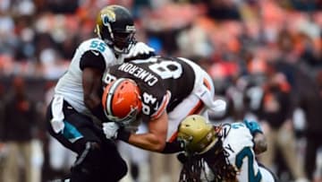Dec 1, 2013; Cleveland, OH, USA; Cleveland Browns tight end Jordan Cameron (84) is tackled by Jacksonville Jaguars outside linebacker Geno Hayes (55) and defensive back Winston Guy (22) in the third quarter at FirstEnergy Stadium. Mandatory Credit: Andrew Weber-USA TODAY Sports