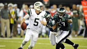 Aug 29, 2013; East Rutherford, NJ, USA; New York Jets quarterback Matt Simms (5) escapes the pressure of Philadelphia Eagles defensive end Everette Brown (57) and linebacker Adrian Robinson (49) during the second half of a preseason game at Metlife Stadium. The Jets won 27-20. Mandatory Credit: Joe Camporeale-USA TODAY Sports