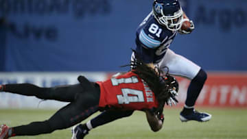 TORONTO, CANADA - NOVEMBER 7: Jason Barnes #7 of the Toronto Argonauts is tackled as he runs with the ball during CFL game action by Abdul Kanneh #14 of the Ottawa Redblacks on November 7, 2014 at Rogers Centre in Toronto, Ontario, Canada. (Photo by Tom Szczerbowski/Getty Images)