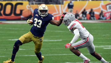 GLENDALE, AZ - JANUARY 01: Running back Josh Adams #33 of the Notre Dame Fighting Irish stiff arms cornerback Gareon Conley #8 of the Ohio State Buckeyes during the first quarter of the BattleFrog Fiesta Bowl at the University of Phoenix Stadium on January 1, 2016 in Glendale, Arizona. (Photo by Norm Hall/Getty Images)
