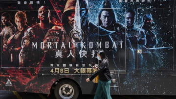 HONG KONG, CHINA - 2021/04/11: A woman walks past a commercial advertisement truck from game based Mortal Kombat movie in Hong Kong. (Photo by Budrul Chukrut/SOPA Images/LightRocket via Getty Images)