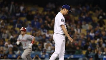 LOS ANGELES, CA - MAY 11: Pitcher Kenta Maeda #18 of the Los Angeles Dodgers reacts after giving up a two-run homerun to Scooter Gennett #3 of the Cincinnati Reds, in the background rounding third base, in the fifth inning during the MLB game at Dodger Stadium on May 11, 2018 in Los Angeles, California. (Photo by Victor Decolongon/Getty Images)