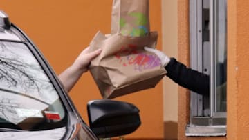 A customer at a Taco Bell drive through window. (Photo by Bruce Bennett/Getty Images)