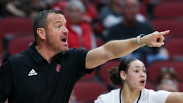 U of L head coach Jeff Walz shouts instructions to his team as he gets some help from Mykasa Robinson (5) on the bench against IUPUI during their game at the Yum Center in Louisville, Ky. on Nov. 10, 2022.Uofl Iupui 22 Sam