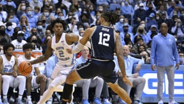 CHAPEL HILL, NORTH CAROLINA - FEBRUARY 05: Caleb Love #2 of the North Carolina Tar Heels drives against Theo John #12 of the Duke Blue Devils during their game at the Dean E. Smith Center on February 05, 2022 in Chapel Hill, North Carolina. Duke won 87-67. (Photo by Grant Halverson/Getty Images)