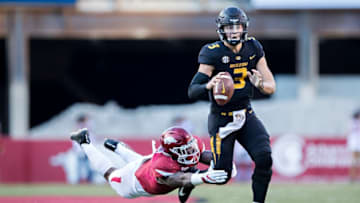 FAYETTEVILLE, AR - NOVEMBER 24: Drew Lock #3 of the Missouri Tigers runs the ball and is tripped up from behind by De"Jon Harris #8 of the Arkansas Razorbacks at Razorback Stadium on November 24, 2017 in Fayetteville, Arkansas. The Tigers defeated the Razorbacks 48-45. (Photo by Wesley Hitt/Getty Images)