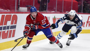 Jun 6, 2021; Montreal, Quebec, CAN; Montreal Canadiens forward Cole Caufield (22) plays the puck and Winnipeg Jets defenseman Logan Stanley (64) defends during the second period in game three of the second round of the 2021 Stanley Cup Playoffs at the Bell Centre. Mandatory Credit: Eric Bolte-USA TODAY Sports