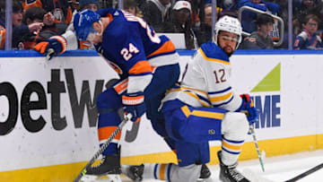 Mar 7, 2023; Elmont, New York, USA; New York Islanders defenseman Scott Mayfield (24) and Buffalo Sabres left wing Jordan Greenway (12) battle for loose puck during the third period at UBS Arena. Mandatory Credit: Dennis Schneidler-USA TODAY Sports