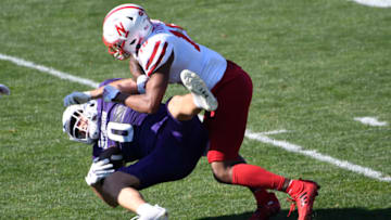 Nebraska Cornhuskers safety Myles Farmer (18) tackles Northwestern Wildcats tight end John Raine (0) - Mandatory Credit: David Banks-USA TODAY Sports