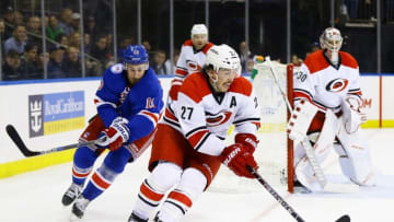 Nov 29, 2016; New York, NY, USA; Carolina Hurricanes degfenseman Justin Faulk (27) plays the puck while being pursued by New York Rangers center Kevin Hayes (13) during the second period at Madison Square Garden. Mandatory Credit: Andy Marlin-USA TODAY Sports