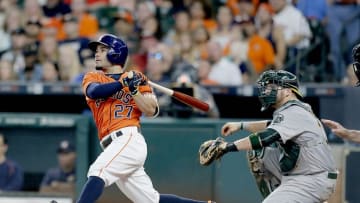 Jul 8, 2016; Houston, TX, USA; Houston Astros designated hitter Jose Altuve (27) hits a single against the Oakland Athletics in the fourth inning at Minute Maid Park. Mandatory Credit: Thomas B. Shea-USA TODAY Sports
