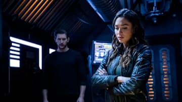 The 100 -- "What You Take With You" -- Image Number: HU609b_0339b.jpg -- Pictured (L-R): Greyston Holt as Gavin and Lindsey Morgan as Raven -- Photo: Jack Rowand/The CW -- © 2019 The CW Network, LLC. All rights reserved.