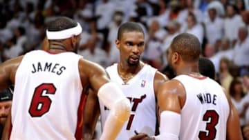 May 8, 2014; Miami, FL, USA; Miami Heat forward LeBron James (left) talks with center Chris Bosh (center) and guard Dwyane Wade (right) during the second half in game two of the second round of the 2014 NBA Playoffs against the Brooklyn Nets at American Airlines Arena. Miami won 94-82. Mandatory Credit: Steve Mitchell-USA TODAY Sports