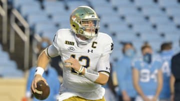 CHAPEL HILL, NORTH CAROLINA - NOVEMBER 27: Ian Book #12 of the Notre Dame Fighting Irish rolls out against the North Carolina Tar Heels during the first half of the game at Kenan Stadium on November 27, 2020 in Chapel Hill, North Carolina. (Photo by Grant Halverson/Getty Images)