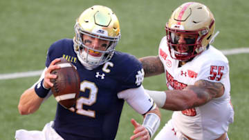 CHESTNUT HILL, MASSACHUSETTS - NOVEMBER 14: Ian Book #12 of the Notre Dame Fighting Irish is pushed out of bounds by Isaiah McDuffie #55 of the Boston College Eagles at Alumni Stadium on November 14, 2020 in Chestnut Hill, Massachusetts. (Photo by Maddie Meyer/Getty Images)