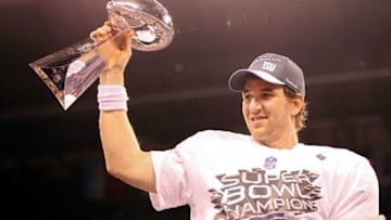 INDIANAPOLIS, IN - FEBRUARY 05: Quarterback Eli Manning #10 of the New York Giants poses with the Vince Lombardi Trophy after the Giants defeated the Patriots by a score of 21-17 in Super Bowl XLVI at Lucas Oil Stadium on February 5, 2012 in Indianapolis, Indiana. (Photo by Ezra Shaw/Getty Images)
