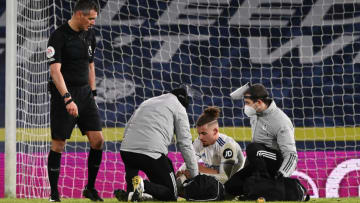 LEEDS, ENGLAND - FEBRUARY 08: Kalvin Phillips of Leeds United receives treatment from staff in PPE during the Premier League match between Leeds United and Crystal Palace at Elland Road on February 08, 2021 in Leeds, England. Sporting stadiums around the UK remain under strict restrictions due to the Coronavirus Pandemic as Government social distancing laws prohibit fans inside venues resulting in games being played behind closed doors. (Photo by Stu Forster/Getty Images)