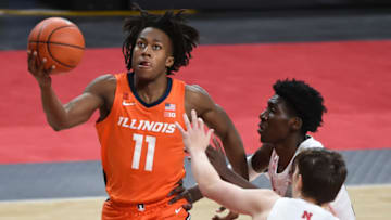 Feb 12, 2021; Lincoln, Nebraska, USA; Illinois Fighting Illini guard Ayo Dosunmu (11) scores against Nebraska Cornhuskers center Eduardo Andre (35) and guard Thorir Thorbjarnarson (34) in the second half at Pinnacle Bank Arena. Mandatory Credit: Steven Branscombe-USA TODAY Sports