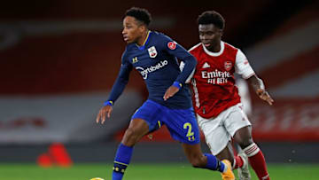 Arsenal's English striker Bukayo Saka (R) vies with Southampton's English defender Kyle Walker-Peters during the English Premier League football match between Arsenal and Southampton at the Emirates Stadium in London on December 16, 2020. (Photo by Adrian DENNIS / POOL / AFP) / RESTRICTED TO EDITORIAL USE. No use with unauthorized audio, video, data, fixture lists, club/league logos or 'live' services. Online in-match use limited to 120 images. An additional 40 images may be used in extra time. No video emulation. Social media in-match use limited to 120 images. An additional 40 images may be used in extra time. No use in betting publications, games or single club/league/player publications. / (Photo by ADRIAN DENNIS/POOL/AFP via Getty Images)