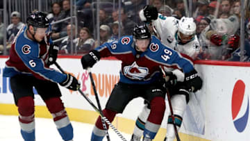 DENVER, COLORADO - JANUARY 02: Erik Johnson #6 and Samuel Girard #49 of the Colorado Avalanche fight for the puck against Evander Kane #9 of the San Jose Sharks in the third period at the Pepsi Center on January 02, 2019 in Denver, Colorado. (Photo by Matthew Stockman/Getty Images)