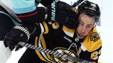 BOSTON, MASSACHUSETTS - JANUARY 12: Brad Marchand #63 of the Boston Bruins collides with Adam Larsson #6 of the Seattle Kraken during the first period at TD Garden on January 12, 2023 in Boston, Massachusetts. (Photo by Maddie Meyer/Getty Images)