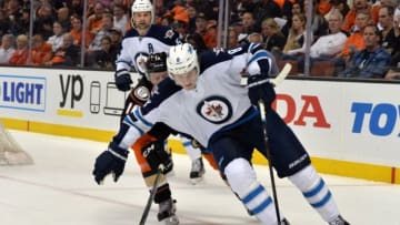 Apr 5, 2016; Anaheim, CA, USA; Winnipeg Jets defenseman Jacob Trouba (8) anad Anaheim Ducks center Ryan Garbutt (16) battle for the puck in the first period during an NHL game at Honda Center. Mandatory Credit: Kirby Lee-USA TODAY Sports