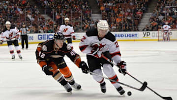 Mar 14, 2016; Anaheim, CA, USA; New Jersey Devils defenseman John Moore (2) and Anaheim Ducks defenseman Josh Manson (42) battle for the puck in the second period during an NHL game at Honda Center. Mandatory Credit: Kirby Lee-USA TODAY Sports