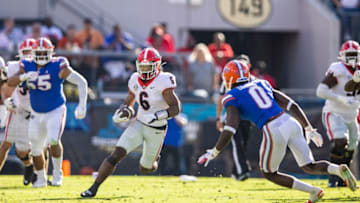 Kenny McIntosh runs for yardage against Trey Dean III. (Photo by James Gilbert/Getty Images)