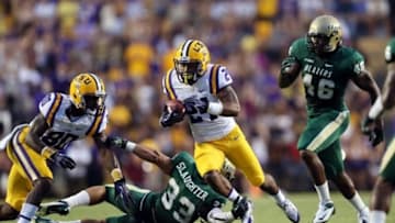 Sep 7, 2013; Baton Rouge, LA, USA; UAB Blazers linebacker Derek Slaughter (33) reaches out to stop LSU Tigers defensive back Jeryl Brazil (24) as he carries the ball during the first quarter at Tiger Stadium. Mandatory Credit: Crystal LoGiudice-USA TODAY Sports