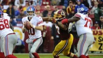 Nov 29, 2015; Landover, MD, USA; New York Giants quarterback Eli Manning (10) attempts to throw the ball as Washington Redskins defensive end Jason Hatcher (97) defends during the second half at FedEx Field. The Redskins won 20-14. Mandatory Credit: Brad Mills-USA TODAY Sports