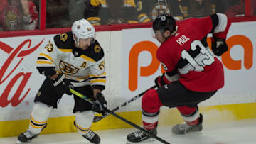 Dec 9, 2019; Ottawa, Ontario, CAN; Boston Bruins left wing Brad Marchand (63) battles with Ottawa Senators left wing Nick Paul (13) in the third period at the Canadian Tire Centre. Mandatory Credit: Marc DesRosiers-USA TODAY Sports
