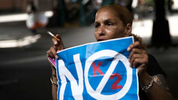 NEW YORK, NY - JULY 14: A neighborhood resident holds up a 'No K2' sign, July 14, 2016 on the border of the Bedford-Stuyvesant and Bushwick neighborhoods in the Brooklyn borough of New York City. Following a wave of suspected K2 overdoes on Tuesday, New York City police raided five convenience stores on Wednesday. (Photo by Drew Angerer/Getty Images)