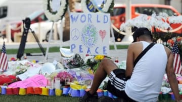 June 14, 2016; Orlando, FL, USA; Jose Martinez sits in front of one of the memorials for victims of the Pulse nightclub shooting at the Dr. Phillips Center for the Performing Arts in downtown Orlando. Mandatory Credit: Craig Bailey/Florida Today via USA TODAY NETWORK