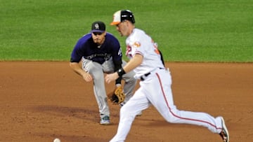 Jul 27, 2016; Baltimore, MD, USA; Colorado Rockies third baseman Nolan Arenado (28) fields a ground ball past Baltimore Orioles catcher Matt Wieters (32) in the fifth inning at Oriole Park at Camden Yards. Mandatory Credit: Evan Habeeb-USA TODAY Sports