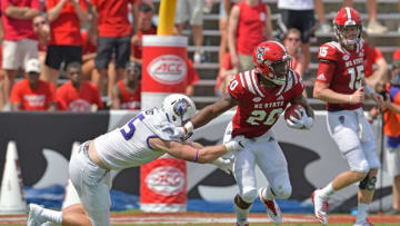 RALEIGH, NC - SEPTEMBER 01: Ricky Person Jr. #20 of the North Carolina State Wolfpack breaks away from Michael Faulkner #75 of the James Madison Dukes during their game at Carter-Finley Stadium on September 1, 2018 in Raleigh, North Carolina. North Carolina State won 24-13. (Photo by Grant Halverson/Getty Images)