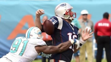 Sep 7, 2014; Miami Gardens, FL, USA; Miami Dolphins defensive end Cameron Wake (91) hits New England Patriots quarterback Tom Brady (12) in the second half at Sun Life Stadium. Miami won 33-20. Mandatory Credit: Brad Barr-USA TODAY Sports