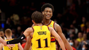 Jan 17, 2022; Atlanta, Georgia, USA; Atlanta Hawks forward De'Andre Hunter (12) celebrates and basket with guard Trae Young (11) during the fourth quarter against the Milwaukee Bucks at State Farm Arena. Mandatory Credit: Jason Getz-USA TODAY Sports
