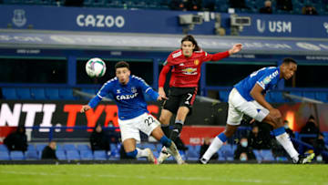 LIVERPOOL, ENGLAND - DECEMBER 23: Edinson Cavani of Manchester United scores their sides first goal whilst under pressure from Ben Godfrey of Everton during the Carabao Cup Quarter Final match between Everton and Manchester United at Goodison Park on December 23, 2020 in Liverpool, England. A limited number of fans (2000) are welcomed back to stadiums to watch elite football across England. This was following easing of restrictions on spectators in tiers one and two areas only. (Photo by Clive Brunskill/Getty Images)